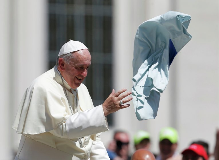 Папа Римский Франциск дарит верующим в Ватикане предмет своей одежды