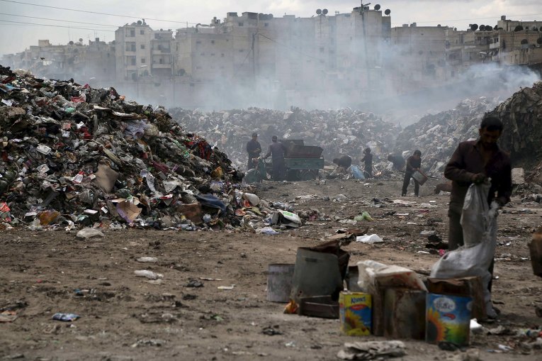 Люди просеивают мусор на свалке в Сирии