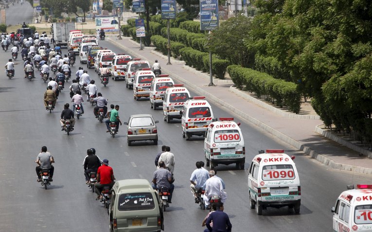 В пакистанском городе Карачи боевики расстреляли автобус, в результате чего погибли 43 человека, больше десятка раненых. На фото: машины скорой помощи перевозят тела погибших.