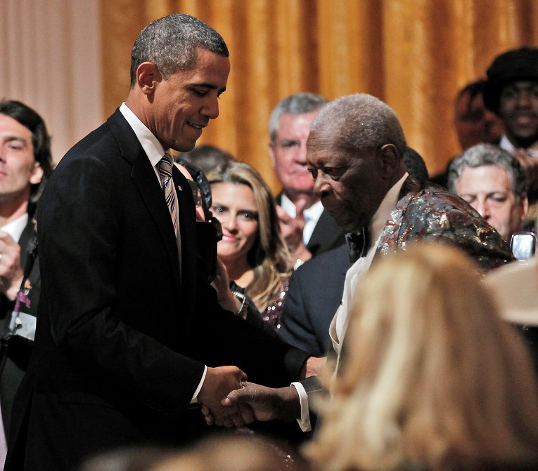 Барак Обама помогает Би Би Кингу подняться на сцену для выступления в Белом доме
