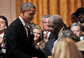 Барак Обама помогает Би Би Кингу подняться на сцену для выступления в Белом доме