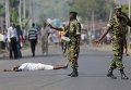 Участник акции протеста лежит не земле перед военным в Бурунди, где в городе Мусага проходят митинги против решения президента страны остаться на третий срок