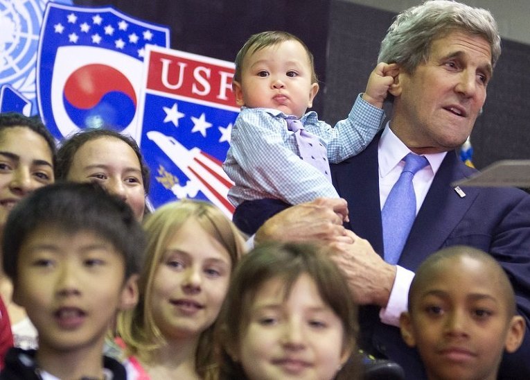 Мальчик держит за ухо госсекретаря США Джона Керри во время его встречи с детьми американских военнослужащих
