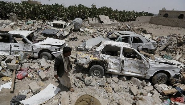 Мужчина идет на месте развалин в районе аэропорта Саны в Йемене