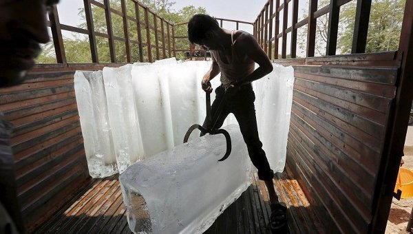 Работник фабрики по производству льда в Индии гузит продукцию перед отправкой на рынок. В Индии в этом году установилась рекордно жаркая погода - температура достигает 44 градусов по Цельсию