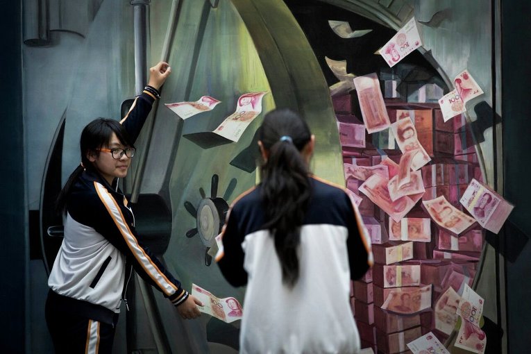 Девушка фотографирует подругу в Пекине на фоне изображения в виде 3D графики на стене