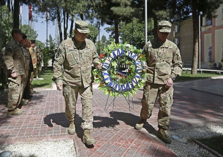 Командующий Международных сил содействия безопасности (ISAF), генерал Джон Кэмпбелл младший несет венок во время церемонии в честь Дня памяти в Кабуле