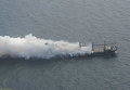 Грузовое судно груженное удобрениями в дыму к западу от Гельголанд, Германия