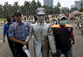 Сотрудники правоохранительных органов забирают уличного музыканта в Джакарте, Индонезия