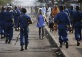 Женщина проходит мимо полицейских во время акции протеста против президента Бурунди Пьера Нкурунзиза и его заявке на третий срок.