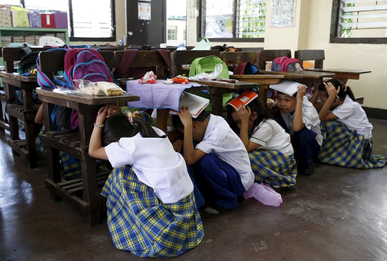 Ученики прячутся под партами во время землетрясения в Маниле на Филиппинах