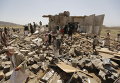 Йеменцы на развалинах домов, разрушенных авиаударами Саудовской Аравии