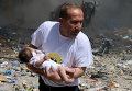 Мужчина с ребенком после удара бомбы в старом городе Алеппо
