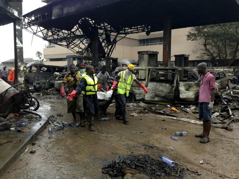 Спасатели несут труп с автозаправочной станции, которая взорвалась ночью в Аккре, Гана
