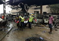 Спасатели несут труп с автозаправочной станции, которая взорвалась ночью в Аккре, Гана
