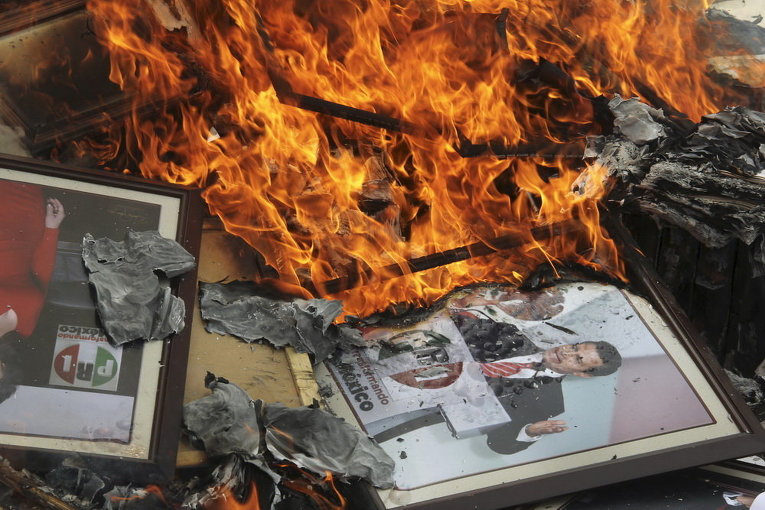 Портрет президента Мексики Энрике Пенья Ньето на куче горящих документов, после того, как члены профсоюза учителей CNTE разгромили местное отделение Институционно-революционной партии (PRI) в Оахака, Мексика
