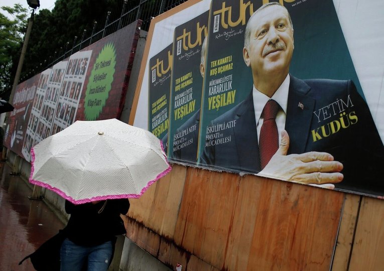 Прохожий в Стамбуле напротив плаката президента  Турции Реджепа Тайипа Эрдогана