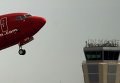 Норвежский самолет взлетает на фоне диспетчерской вышки в Малаге. Испанские диспетчеры объявили четырехдневную забастовку.