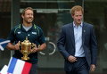 Британский принц Гарри с английским игроком в регби Джонни Уилкинсоном, который держит Кубок мира по регби