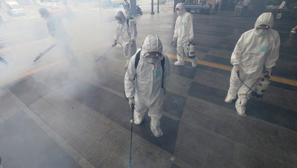 Работники в Сеуле обрабатывают антисептическим раствором улицу из-за распространения коронавируса