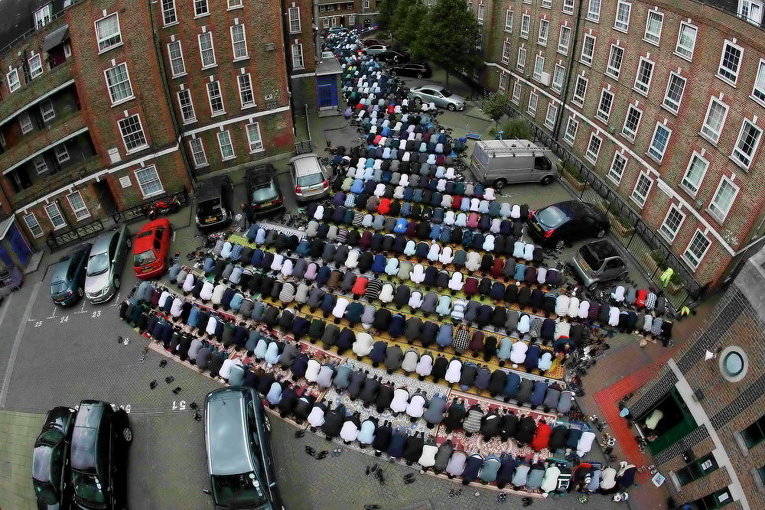 Мусульмане посещают пятничную молитву во второй день Рамадана, во дворе жилого комплекса в восточном Лондоне