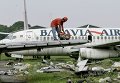 Работник демонтирует заброшенный лайнер в международном аэропорту на окраине Джакарты