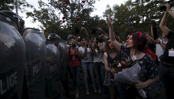 Протестующие бросают лепестки роз в полицию во время акции протеста в Ереване, Армения