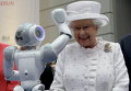 Королева Великобритании Елизавета II улыбается маленькому роботу во время посещения Технического университета в Берлине, Германия