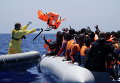 Бельгийский матрос бросает спасательные жилеты для мигрантов во время поисково-спасательной операции в Средиземном море у берегов Ливии