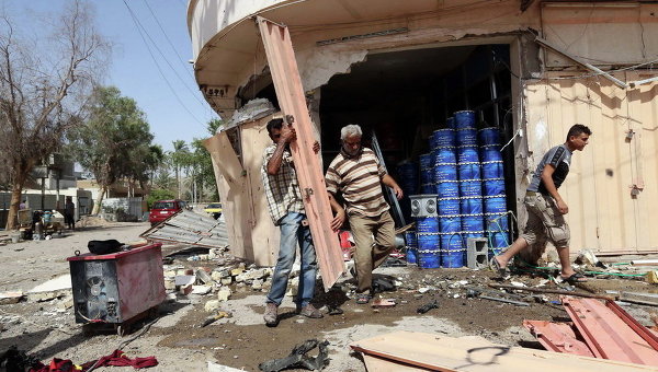 Гражданские осматривают место взрыва заминированного автомобиля в северном районе Багдада, Ирак. Архивное фото