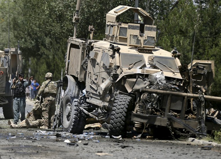Американские солдаты со своим раненым товарищем на месте теракта в Кабуле, Афганистан. Во вторник, 30 июня, террорист-смертник атаковал конвой иностранных войск.