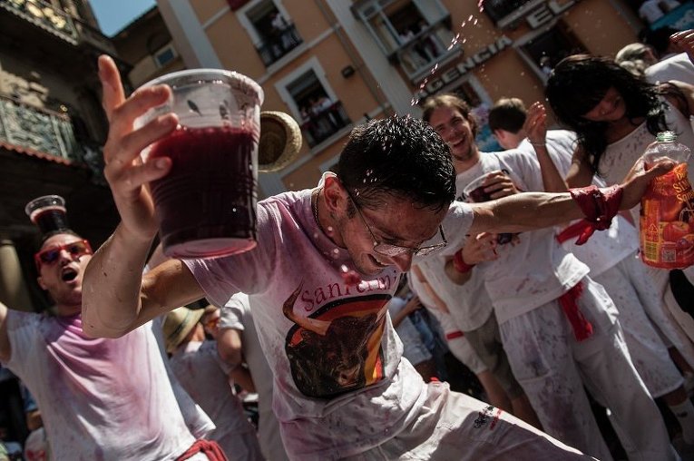 Мужчина празднует открытие забега с быками во время фестиваля Сан-Фермин в Испании