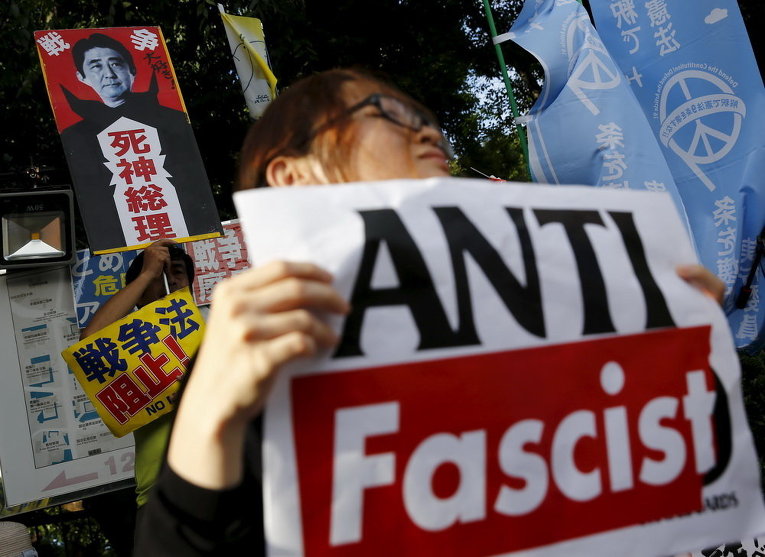 Люди держат плакаты во время митинга против администрации премьер-министра Японии Синдзо Абэ в Токио
