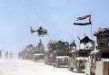 Иракский вертолет пролетает над военной техники в провинции Анбар