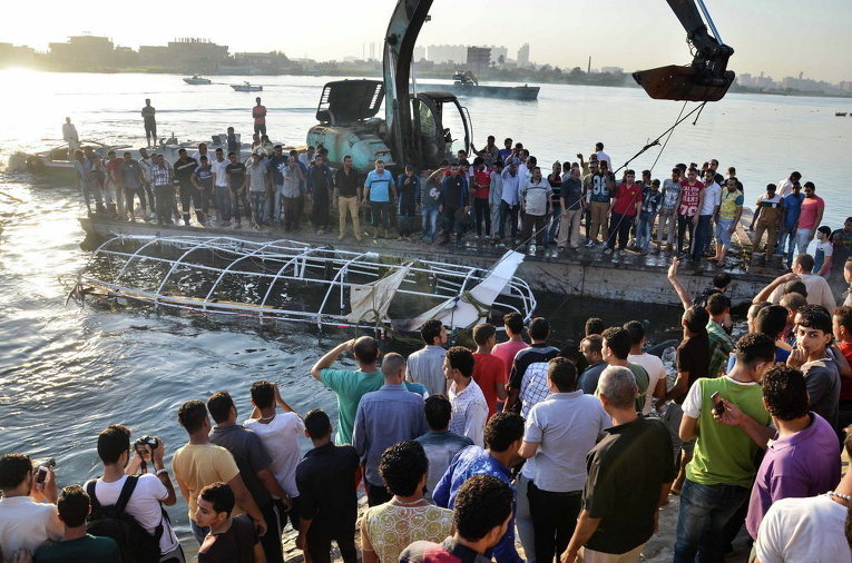 Египтяне смотрят на пассажирский катер, который затонул в реке Нил в Гизе, к югу от Каира, Египет