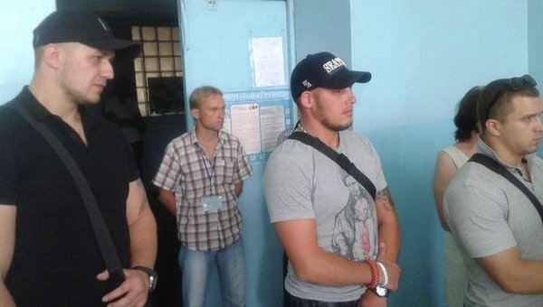 Мужчины охраняют наблюдателя на одном из избирательном участке в Чернигове