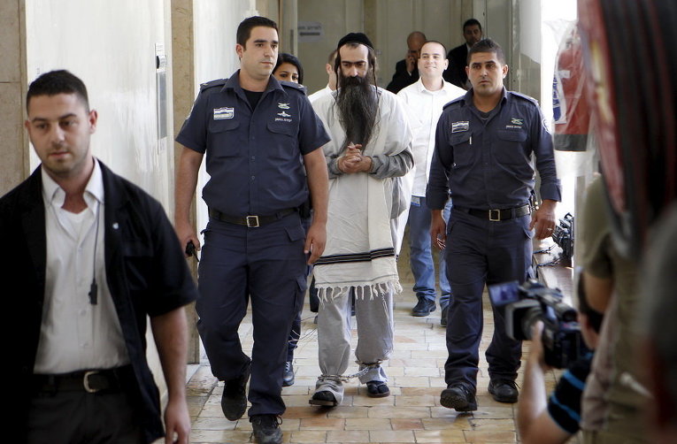 Ишай Шлиссель в сопровождении сотрудников безопасности в Иерусалиме. В четверг на гей-параде он ранил шестерых участников