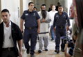 Ишай Шлиссель в сопровождении сотрудников безопасности в Иерусалиме. В четверг на гей-параде он ранил шестерых участников