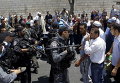 Израильский полицейский и палестинец спорят после пятничной молитвы в Восточном Иерусалиме в районе Рас-Аль-Амоуд