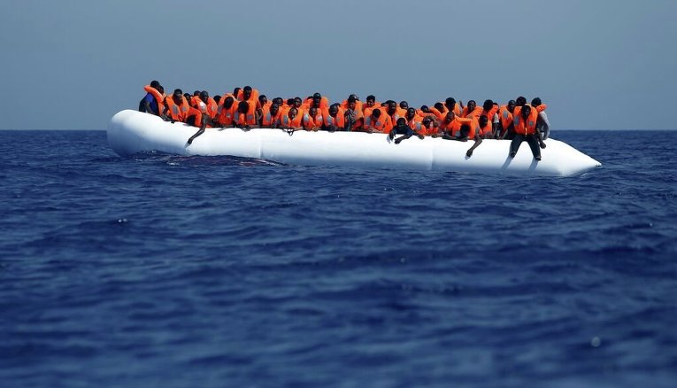 Мигранты на резиновой лодке ожидают прибытия корабля MV Phoenix в 32 километрах от побережья Ливии