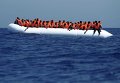 Мигранты на резиновой лодке ожидают прибытия корабля MV Phoenix в 32 километрах от побережья Ливии