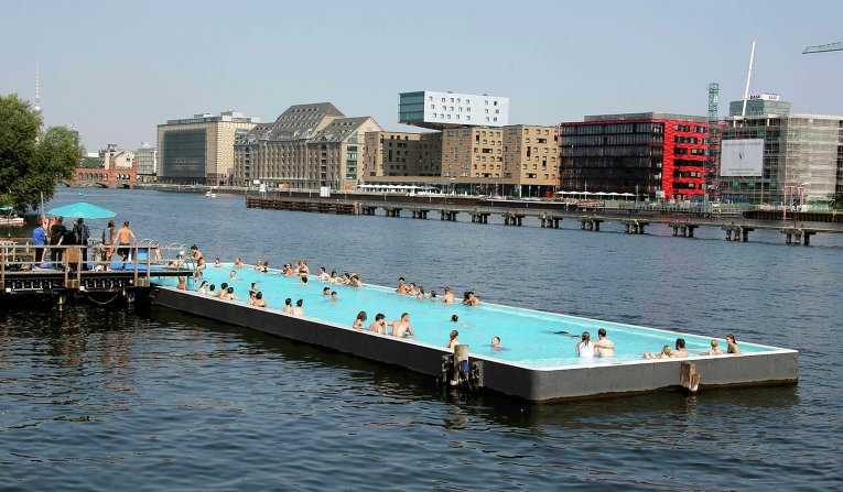 Берлинцы спасаются от жары в передвижном бассейне, что на реке Шпрее, Германия