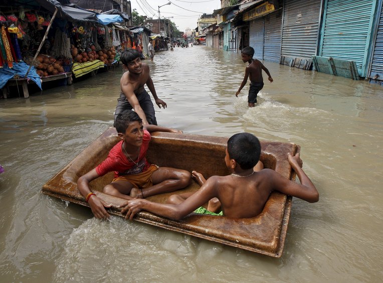Мальчики играют на затопленных улицах Индии, которая страдает от наподнения