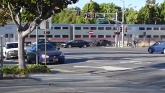 Полицейский вытащили мужчину из авто за секунду до столкновения с поездом. Видео