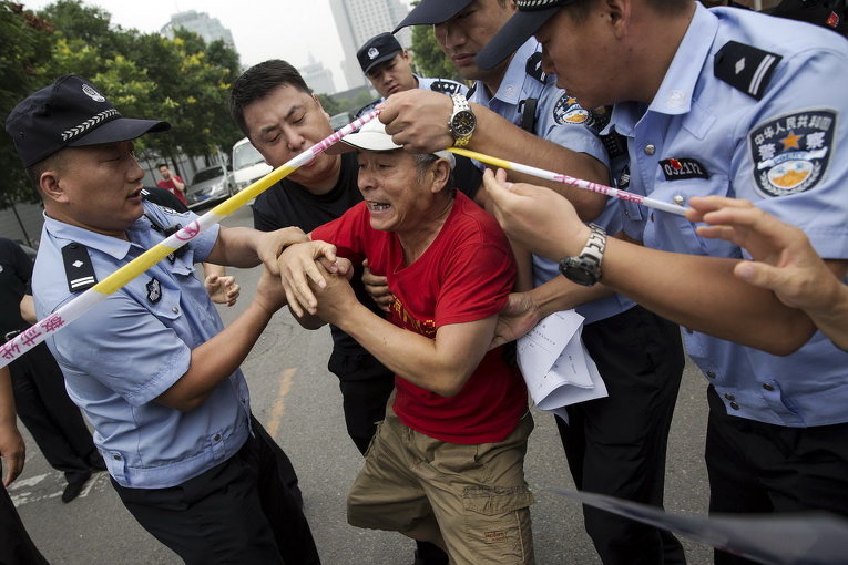 Полиция пытается остановить мужчину, чей родственник был на борту рейса Malaysia Airlines MH370, который пытается попасть в Посольство Малайзии в Пекине