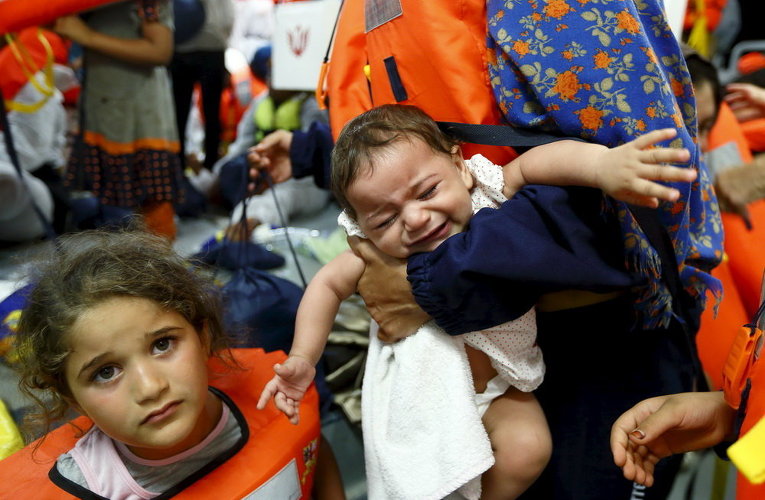 Дети мигрантов ждут, когда смогут перейти на корабль Норвегии у берегов Ливии