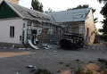 Разрушенный в результате обстрела дом и сгоревшая автомашина на одной из улиц Иловайска