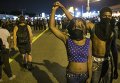 Демонстранты в Фергюсоне, где продолжаются протесты в связи с годовщиной гибели подростка-афроамериканца Майкла Брауна от рук полицейского