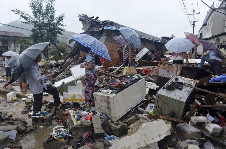 ИТОГИ Жители ищут свои вещи среди обломков рухнувших домов, разрушенных в результате наводнений в Китае