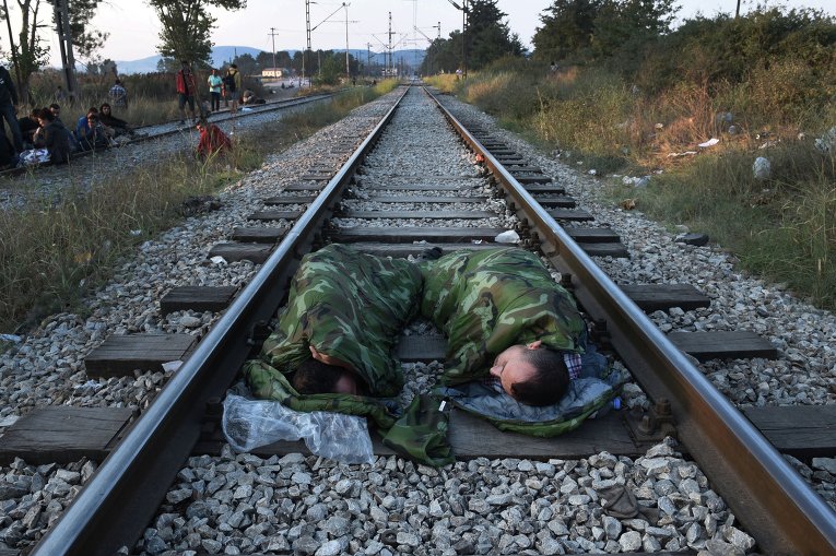 Сирийские беженцы спят на железнодорожных путях вблизи железнодорожного вокзала Идомени, Северная Греция